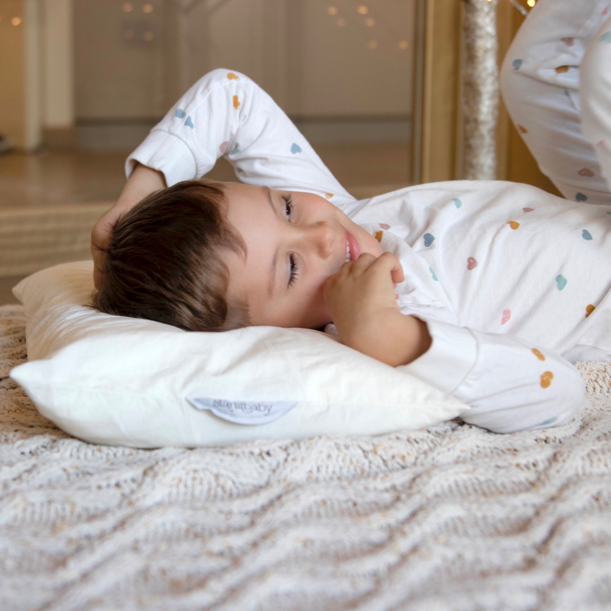 Piccolo che riposa con il Cuscino Starlit nel suo letto